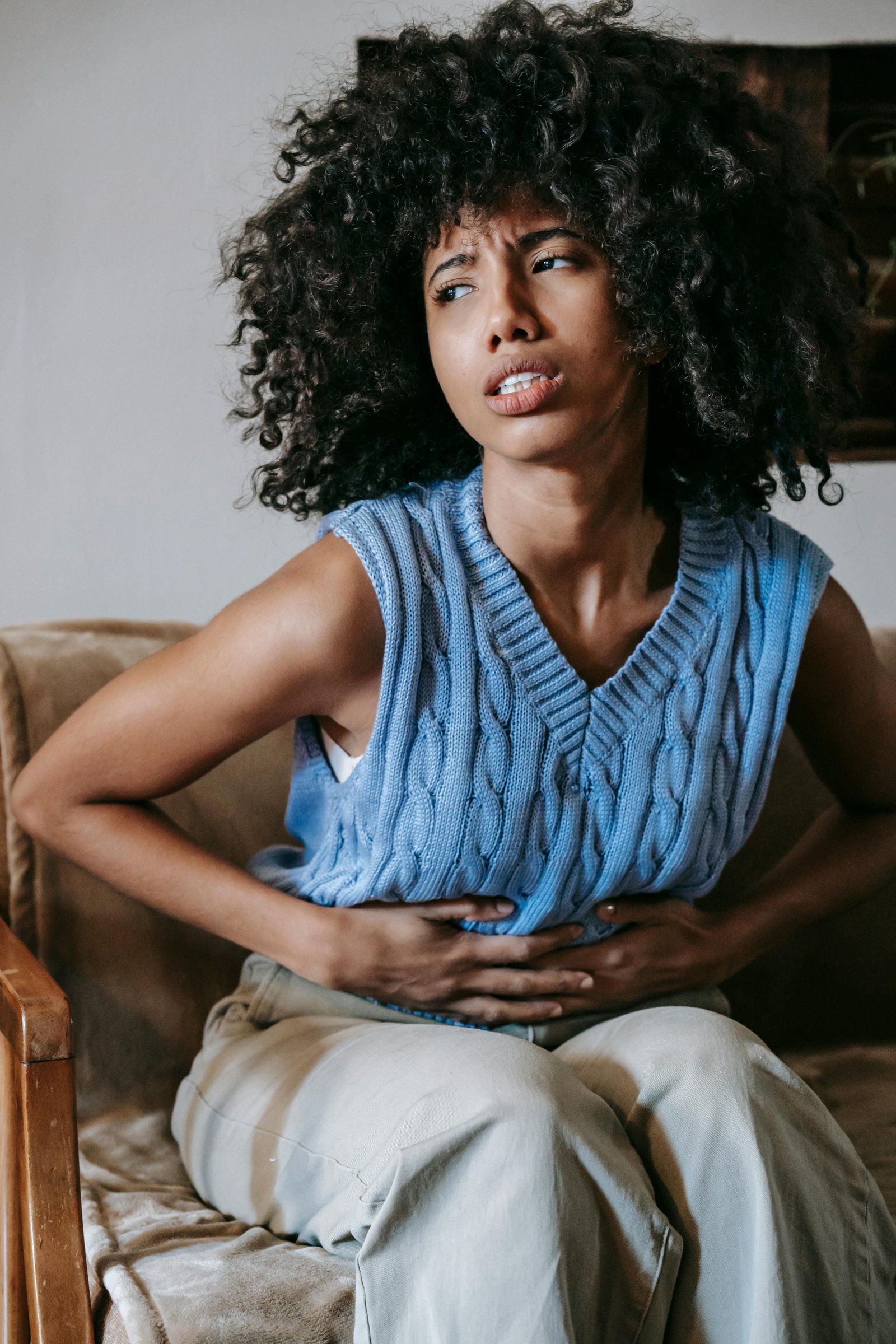 Mujer joven con dolor abdominal agudo, síntoma común de cálculos biliares o vesícula inflamada