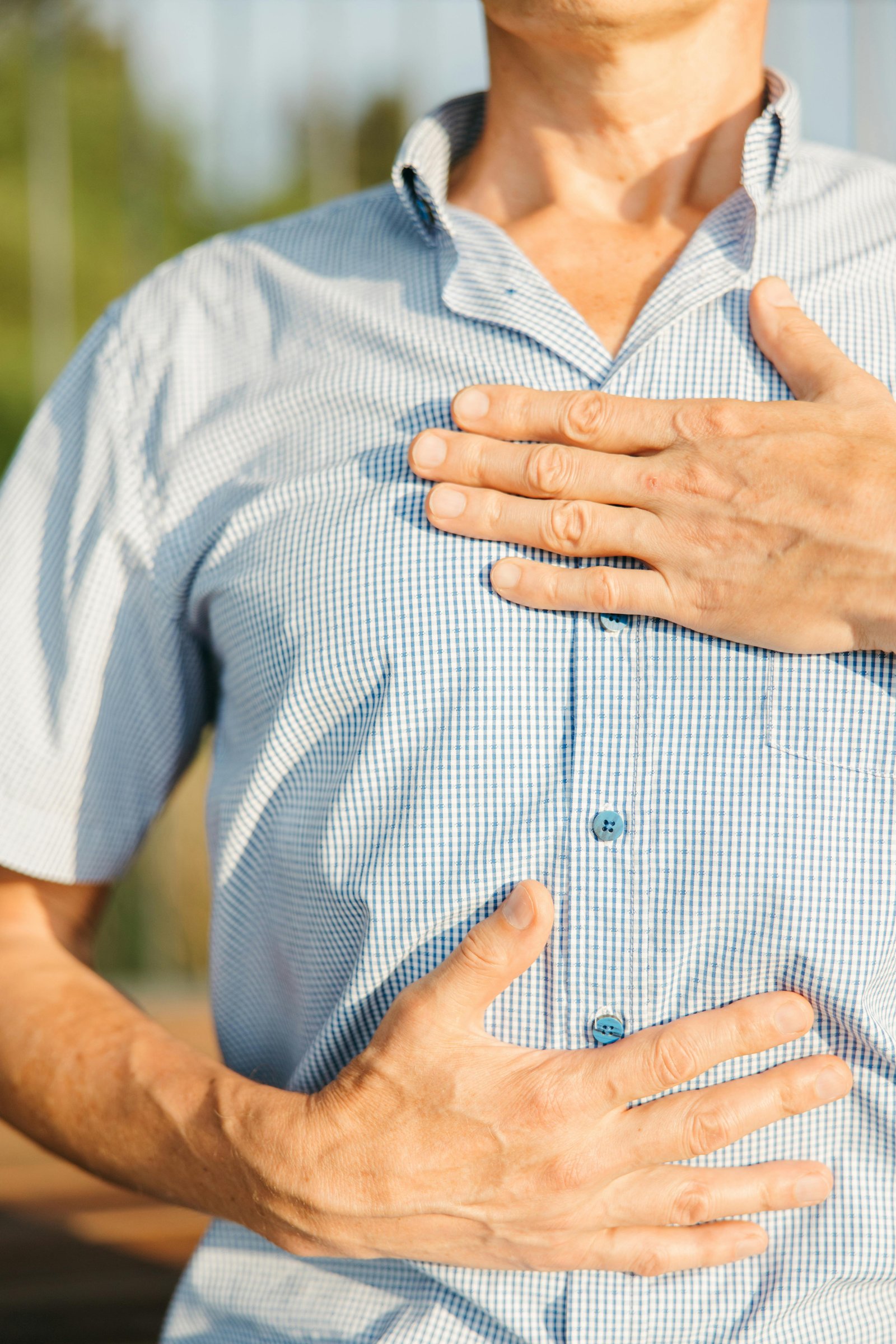Hombre sujetando pecho y estómago por agruras frecuentes y síntomas de hernia hiatal en CDMX